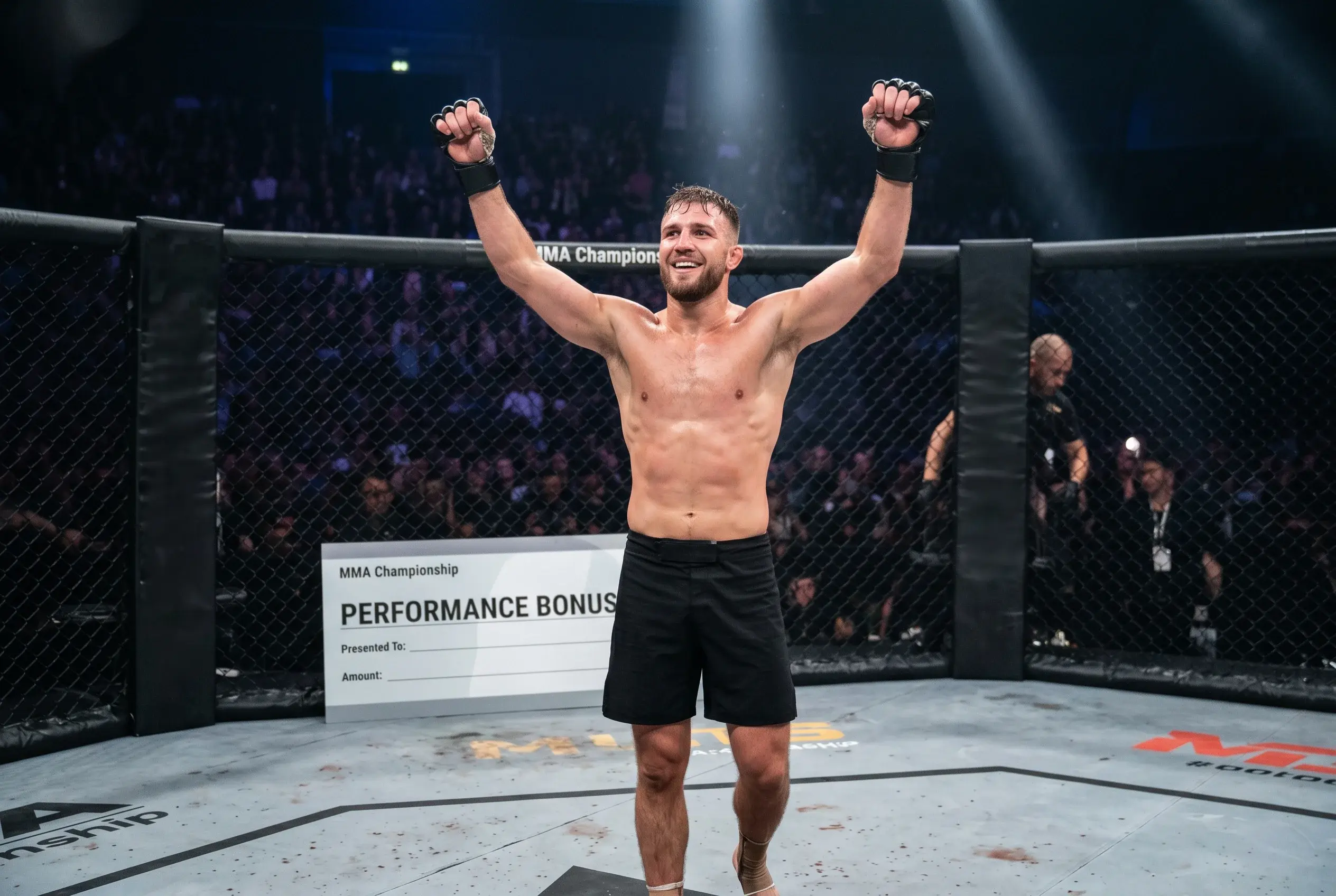 Stylised oversized cheque mounted on the cage with a UFC fighter celebrating in the foreground after a performance bonus win